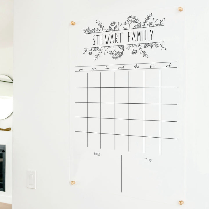 A Dry-erase monthly calender made of acrylic hanging on the wall