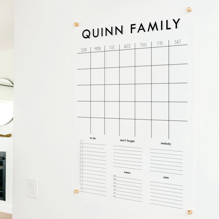 A Dry-erase family command center made of acrylic hanging on the wall