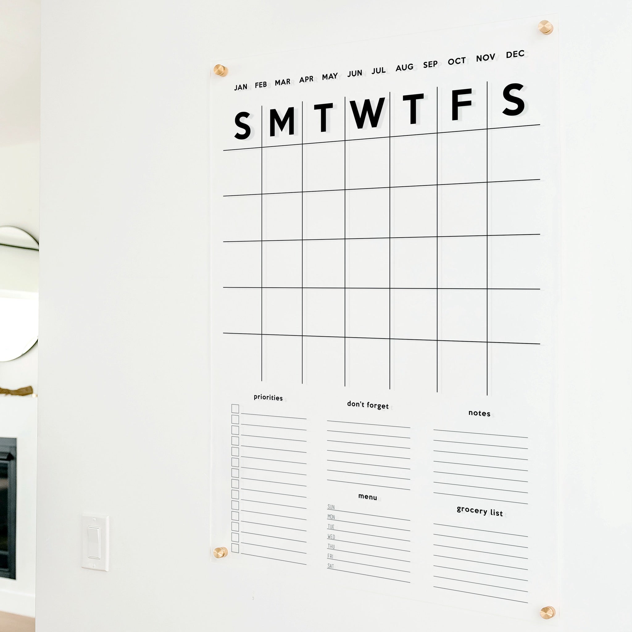A Dry-erase family command center made of acrylic hanging on the wall