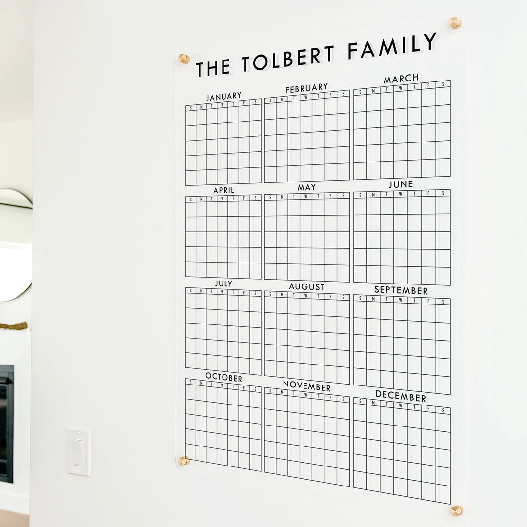 A dry-erase yearly calendar made of acrylic hanging up on the wall