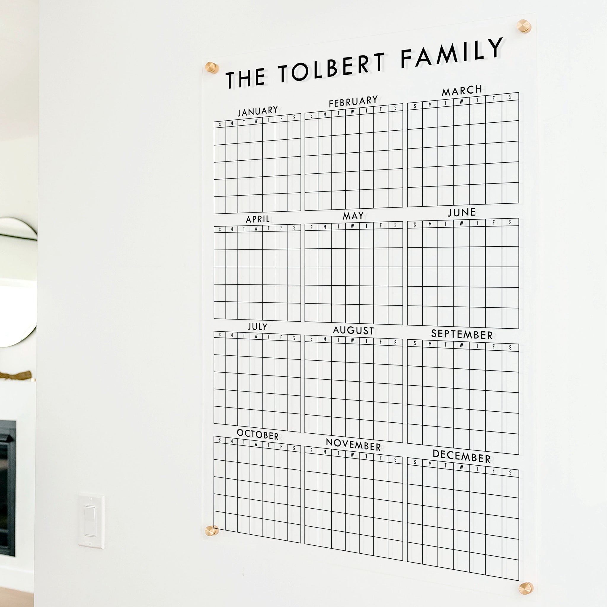 A dry-erase yearly calendar made of acrylic hanging up on the wall