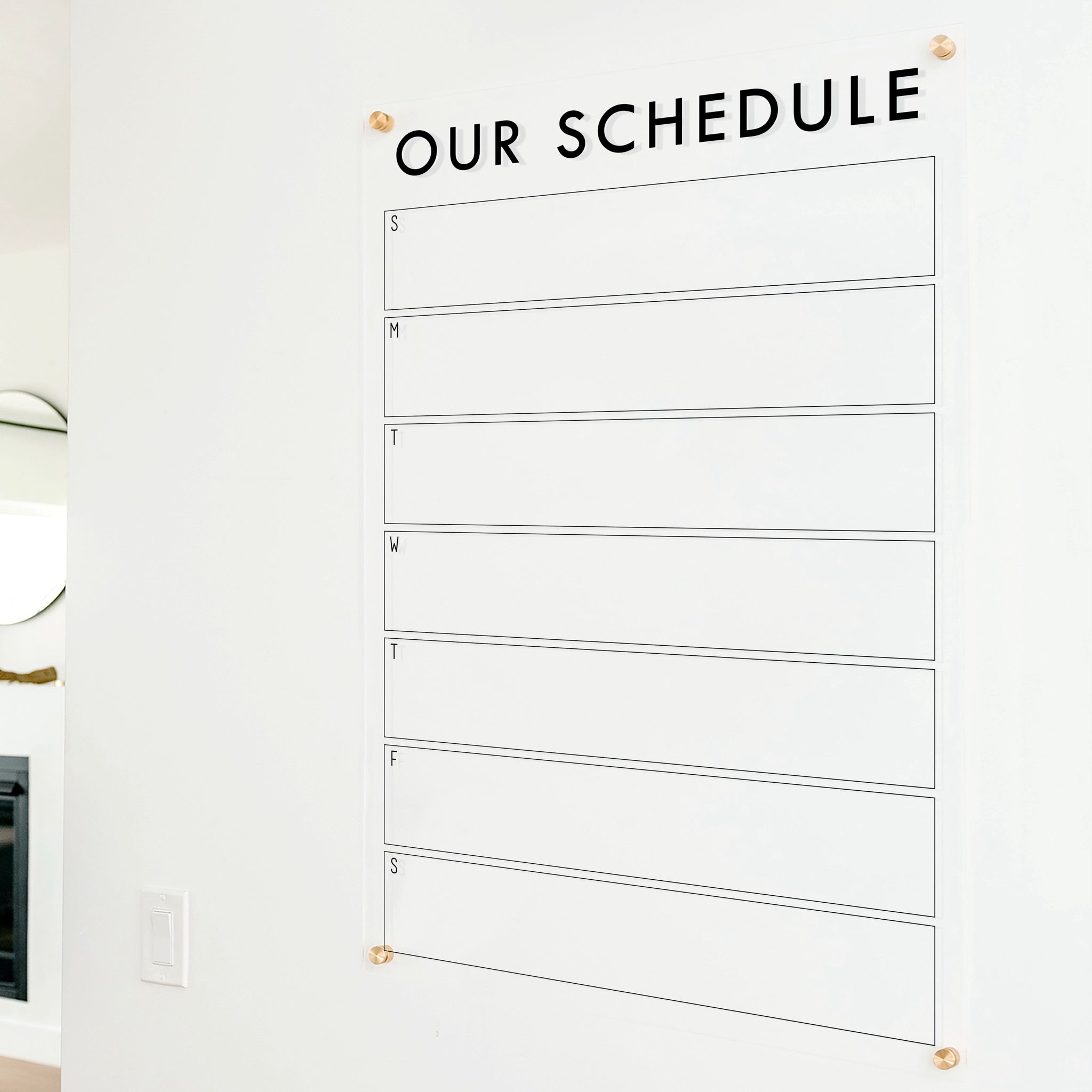 A Dry-erase weekly calender made of acrylic hanging on the wall
