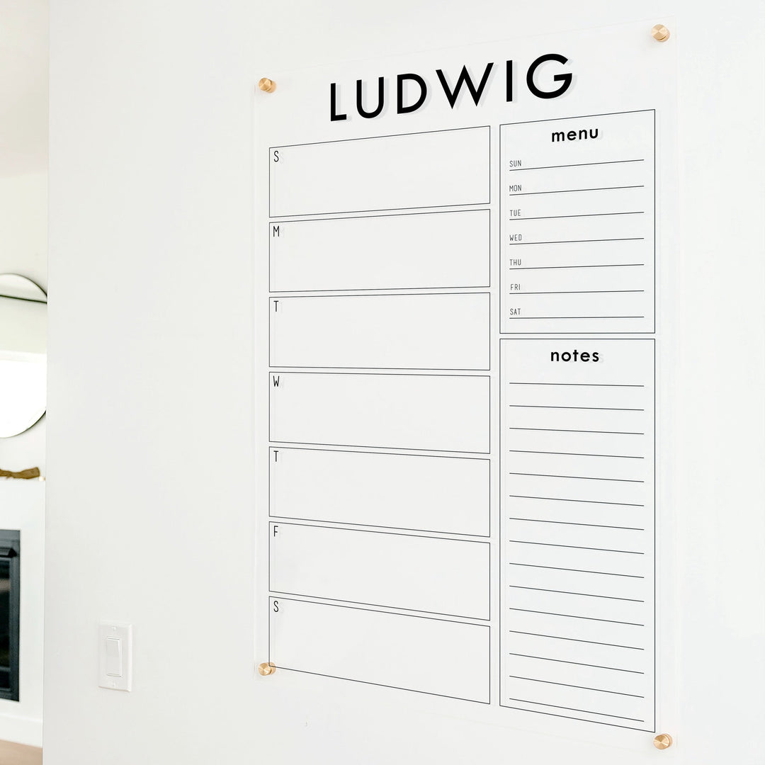 A Dry-erase weekly calender made of acrylic hanging on the wall