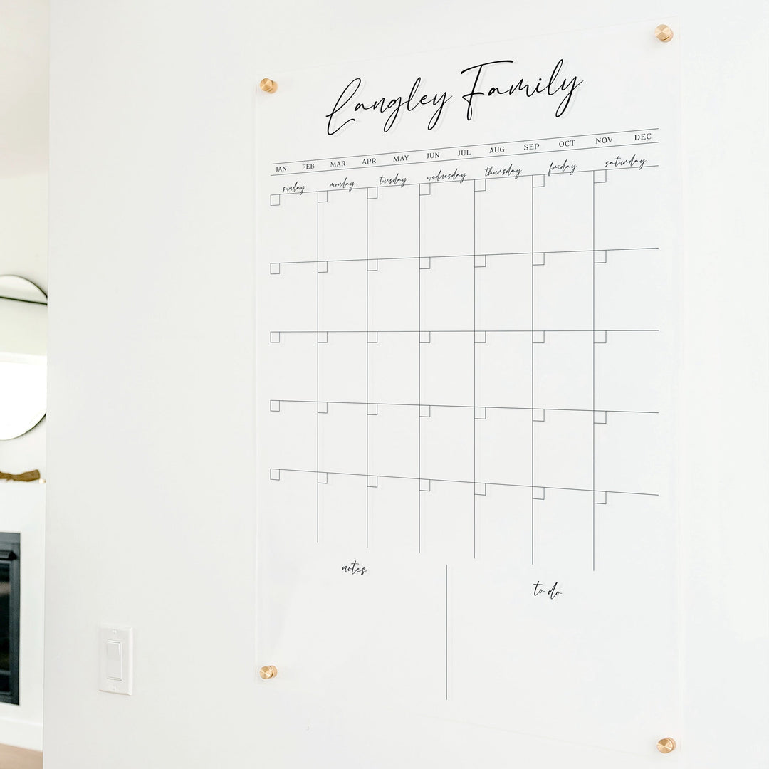 A Dry-erase monthly calender made of acrylic hanging on the wall