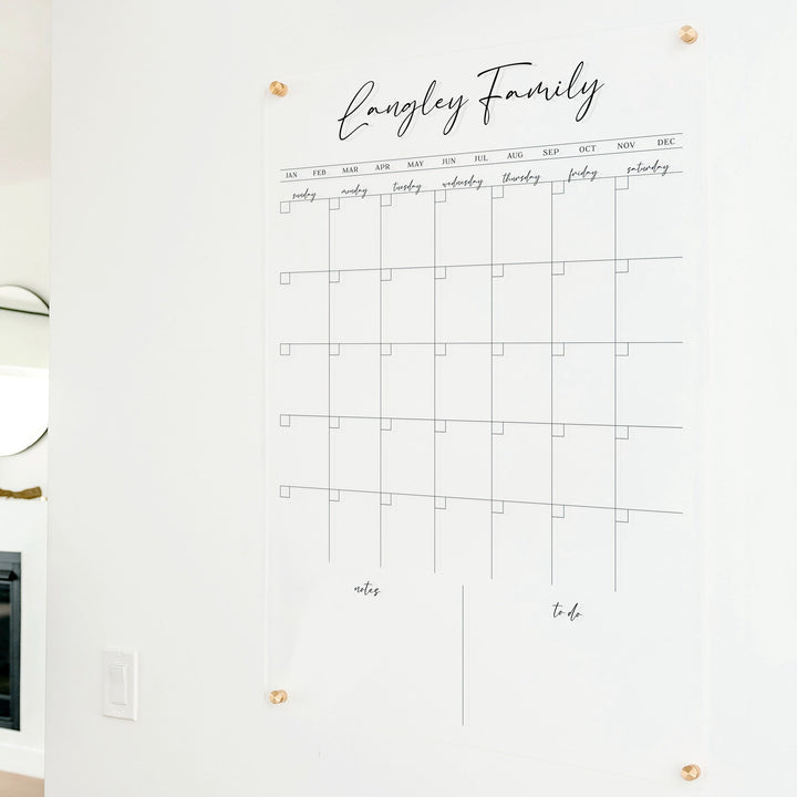 A Dry-erase monthly calender made of acrylic hanging on the wall