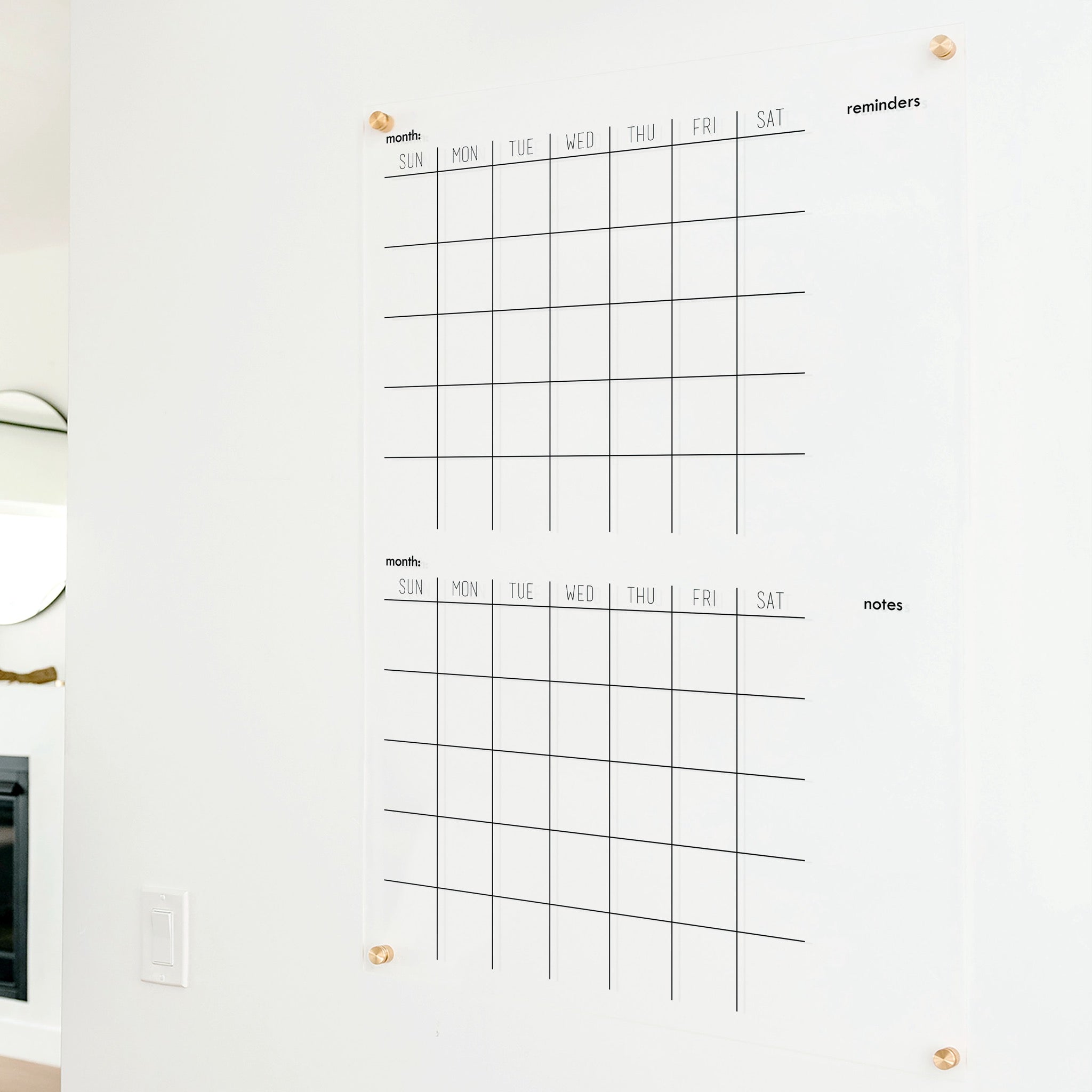 A Dry-erase acrylic calendar with a two month design format hanging on the wall