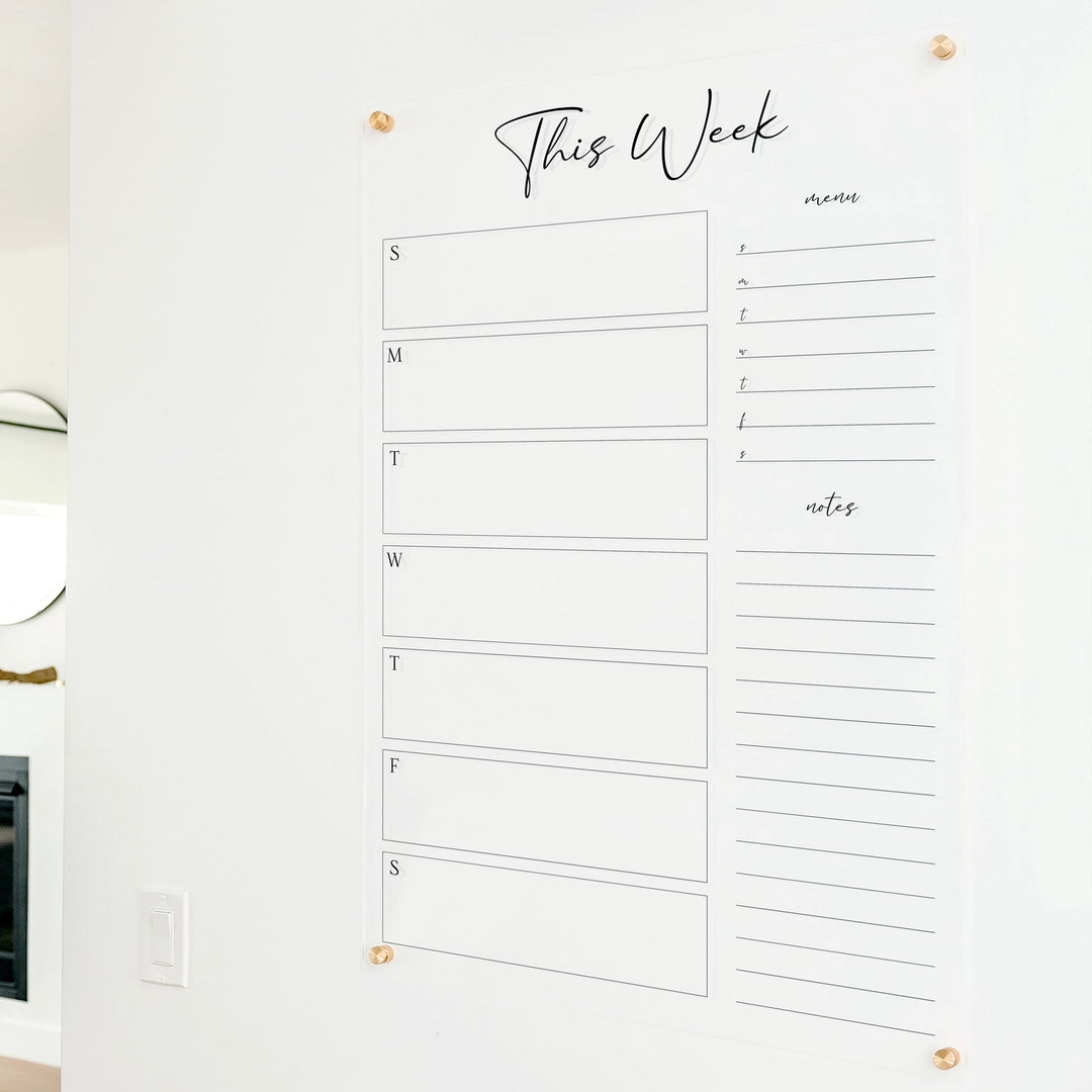 A Dry-erase weekly calender made of acrylic hanging on the wall