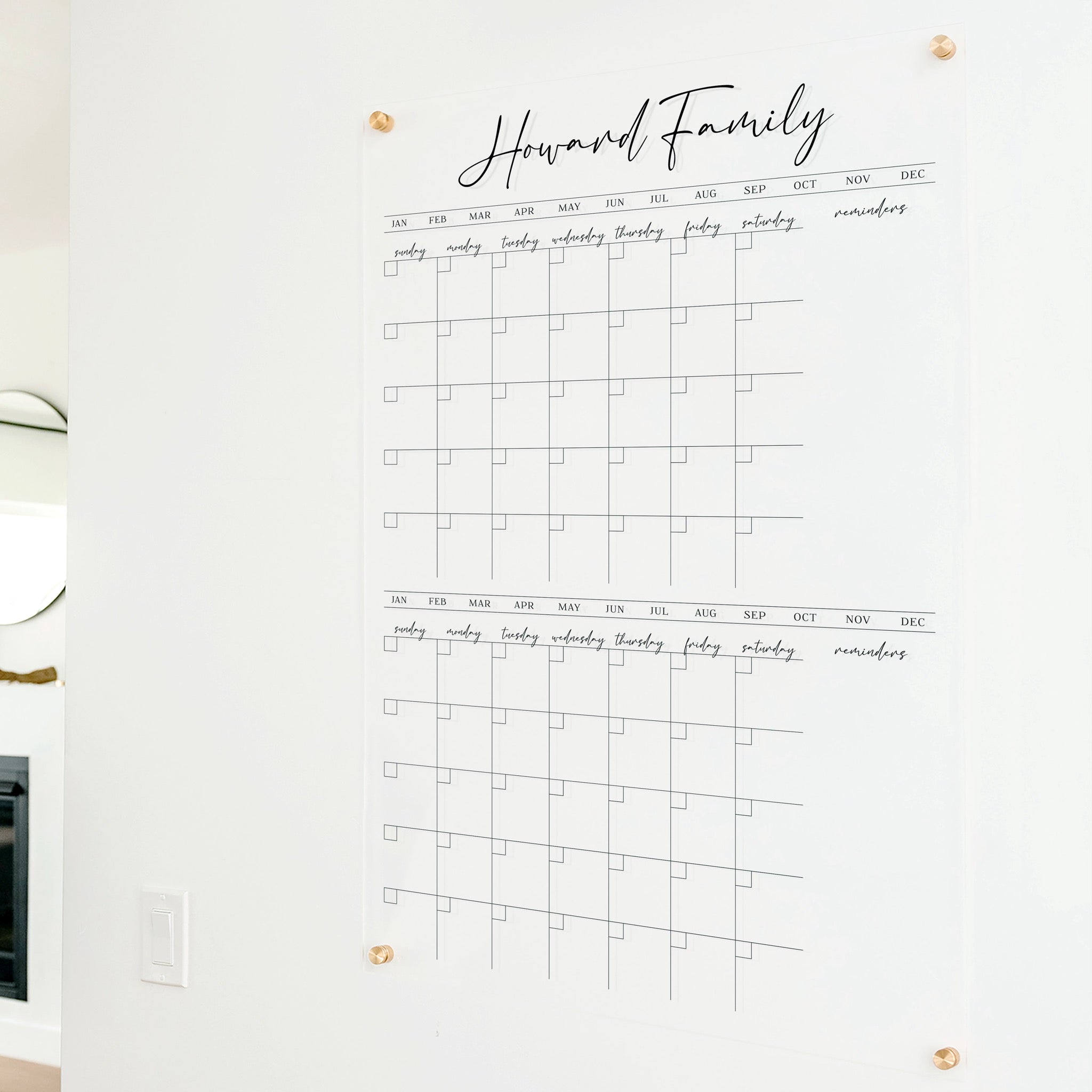 A Dry-erase acrylic calendar with a two month design format hanging on the wall