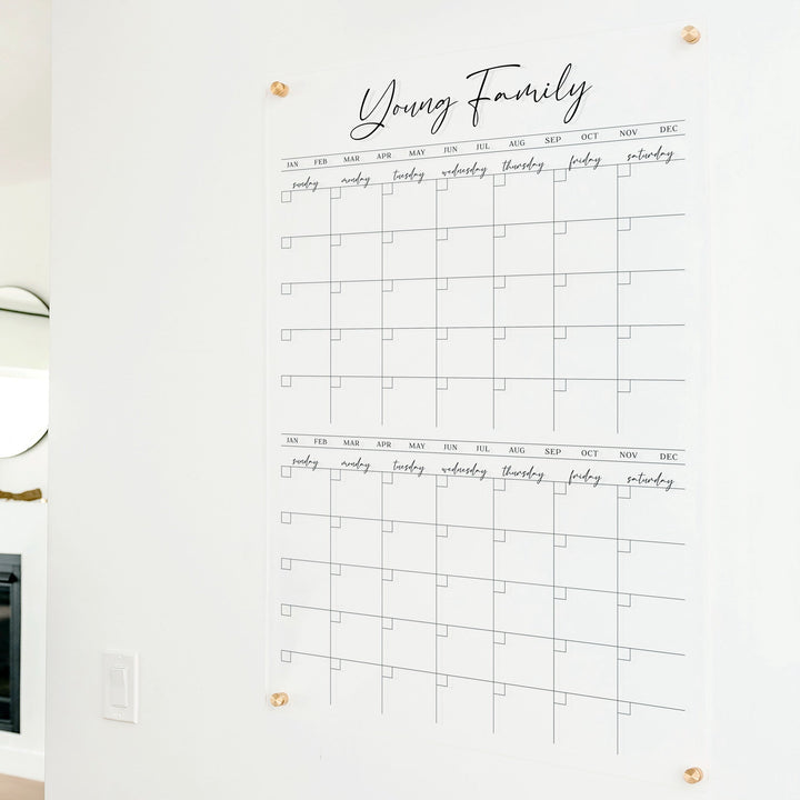 A Dry-erase acrylic calendar with a two month design format hanging on the wall