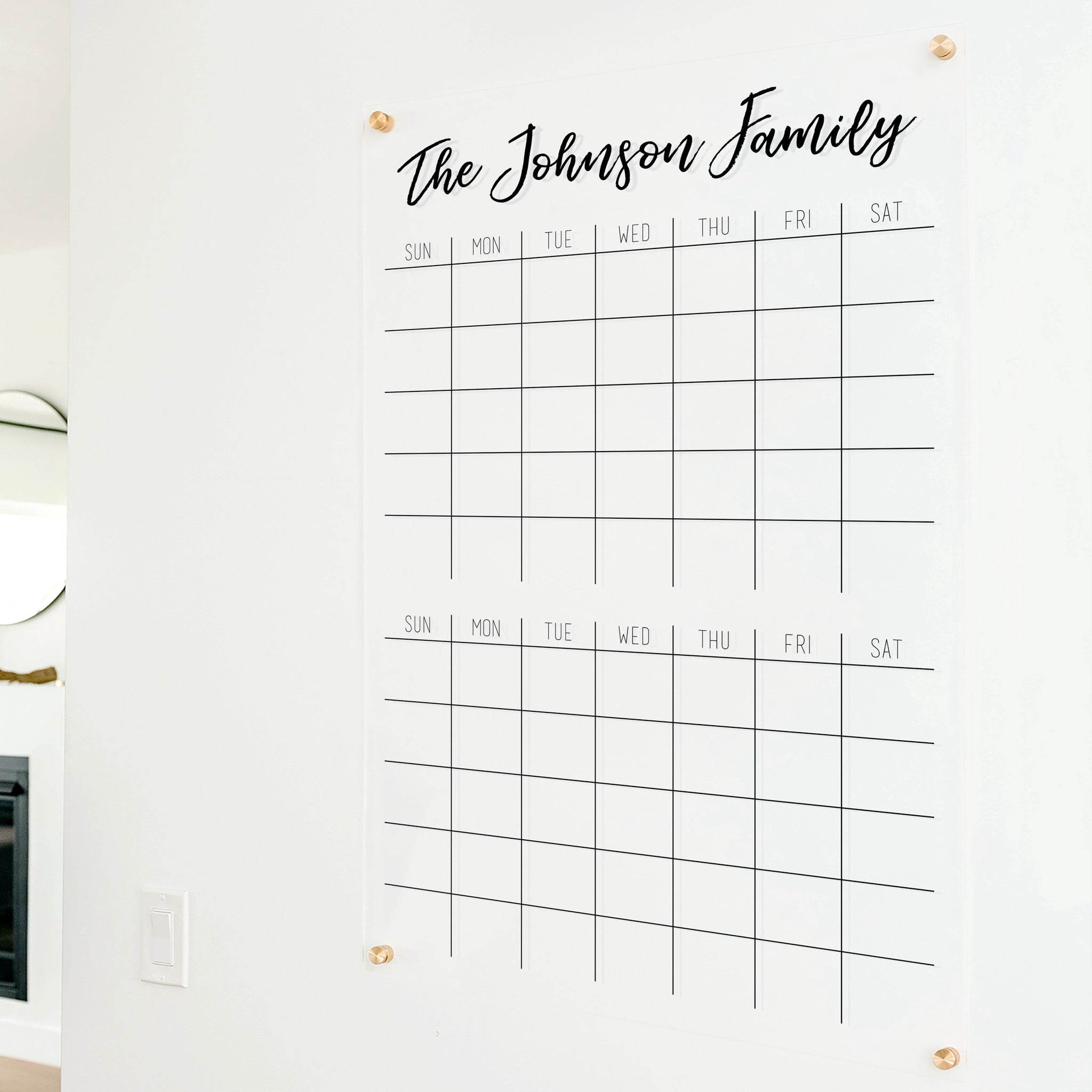 A Dry-erase acrylic calendar with a two month design format hanging on the wall