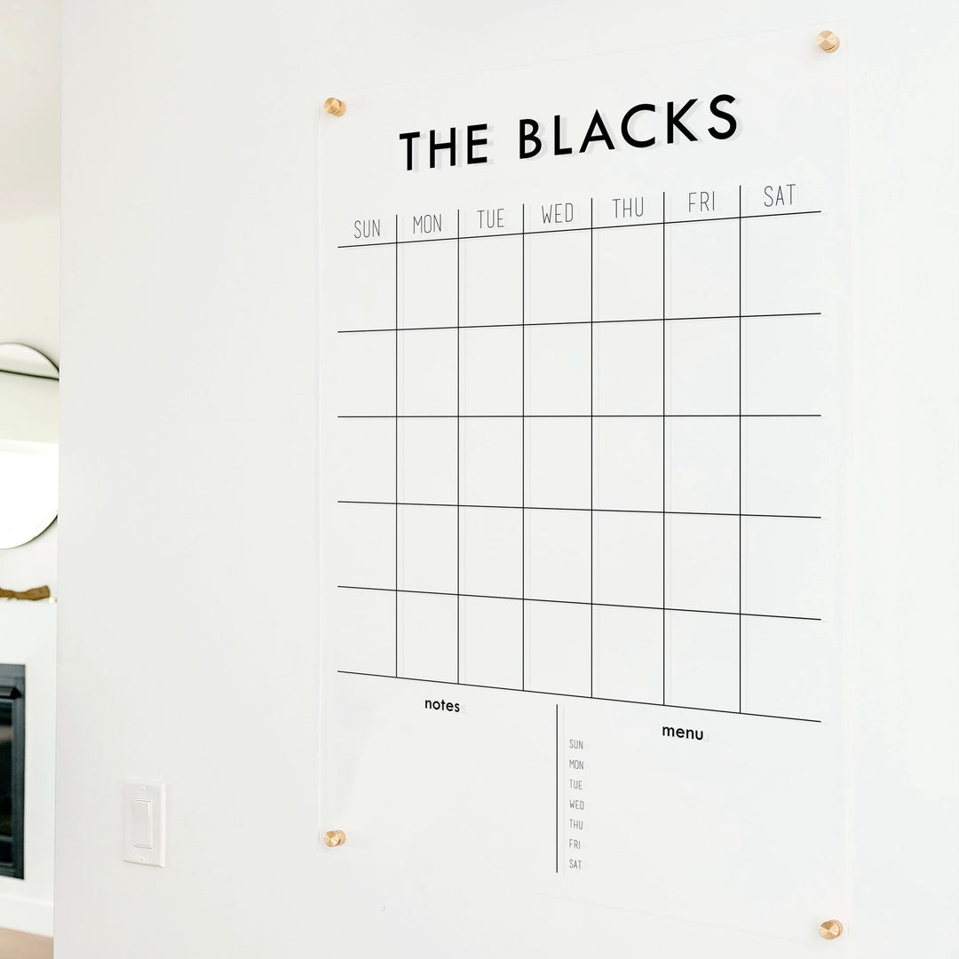 A Dry-erase monthly calender made of acrylic hanging on the wall