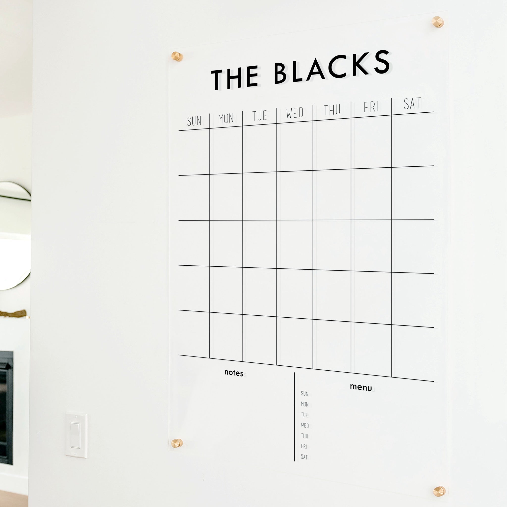 A Dry-erase monthly calender made of acrylic hanging on the wall