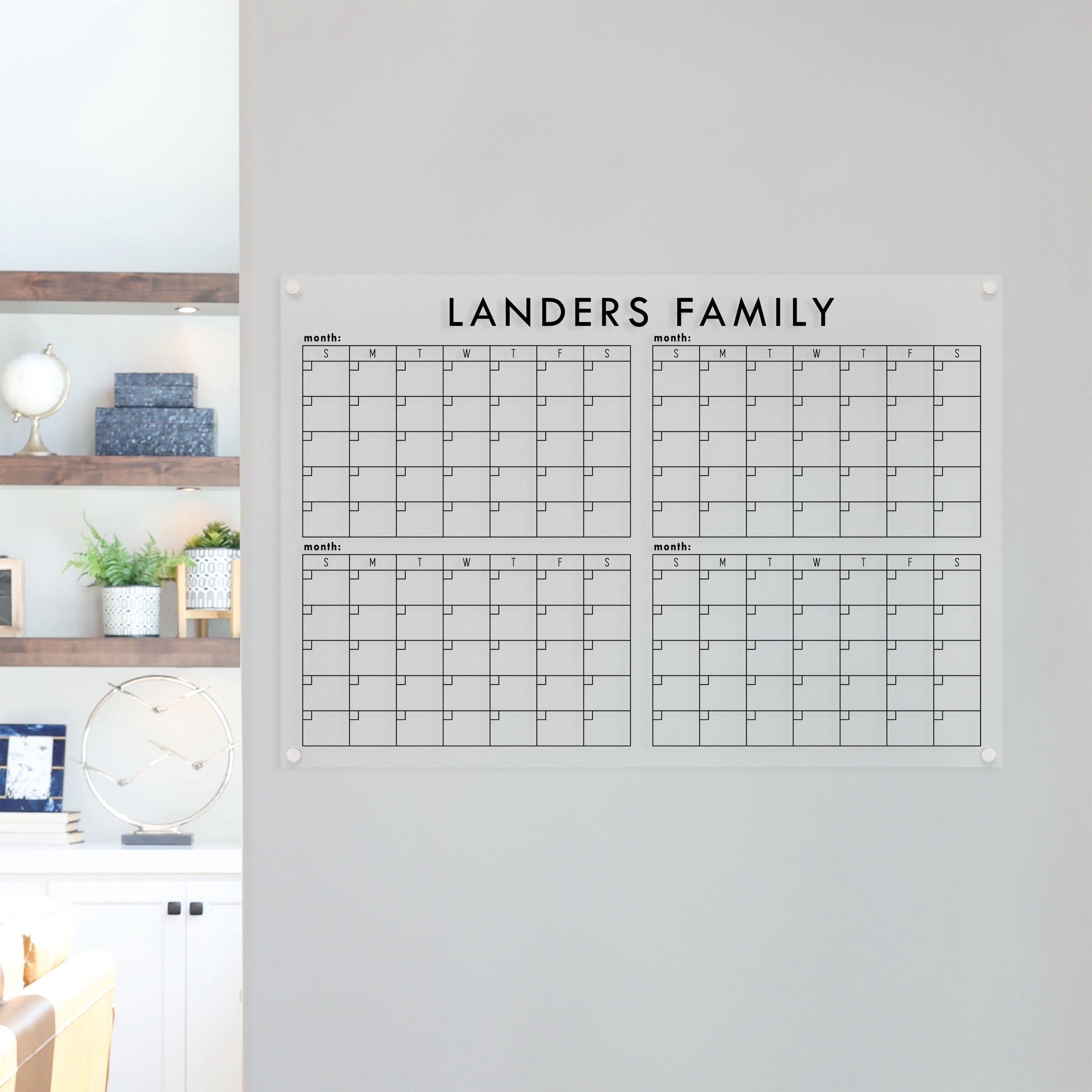 A dry-erase four month calendar made of acrylic hanging on the wall