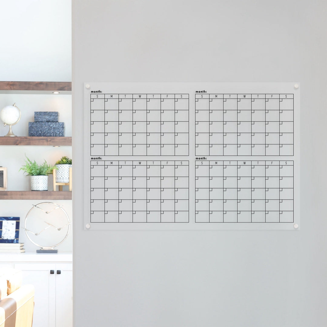 A dry-erase four month calendar made of acrylic hanging on the wall