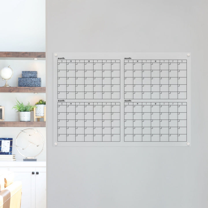 A dry-erase four month calendar made of acrylic hanging on the wall