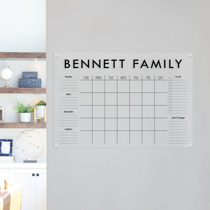 A Dry-erase family command center made of acrylic hanging on the wall