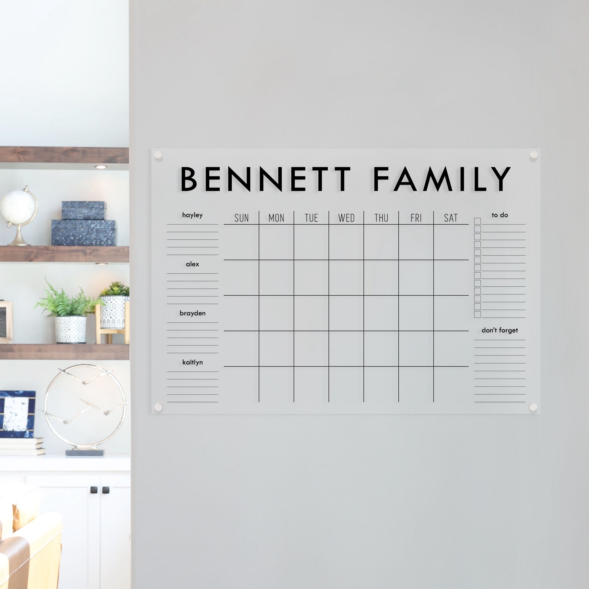 A Dry-erase family command center made of acrylic hanging on the wall