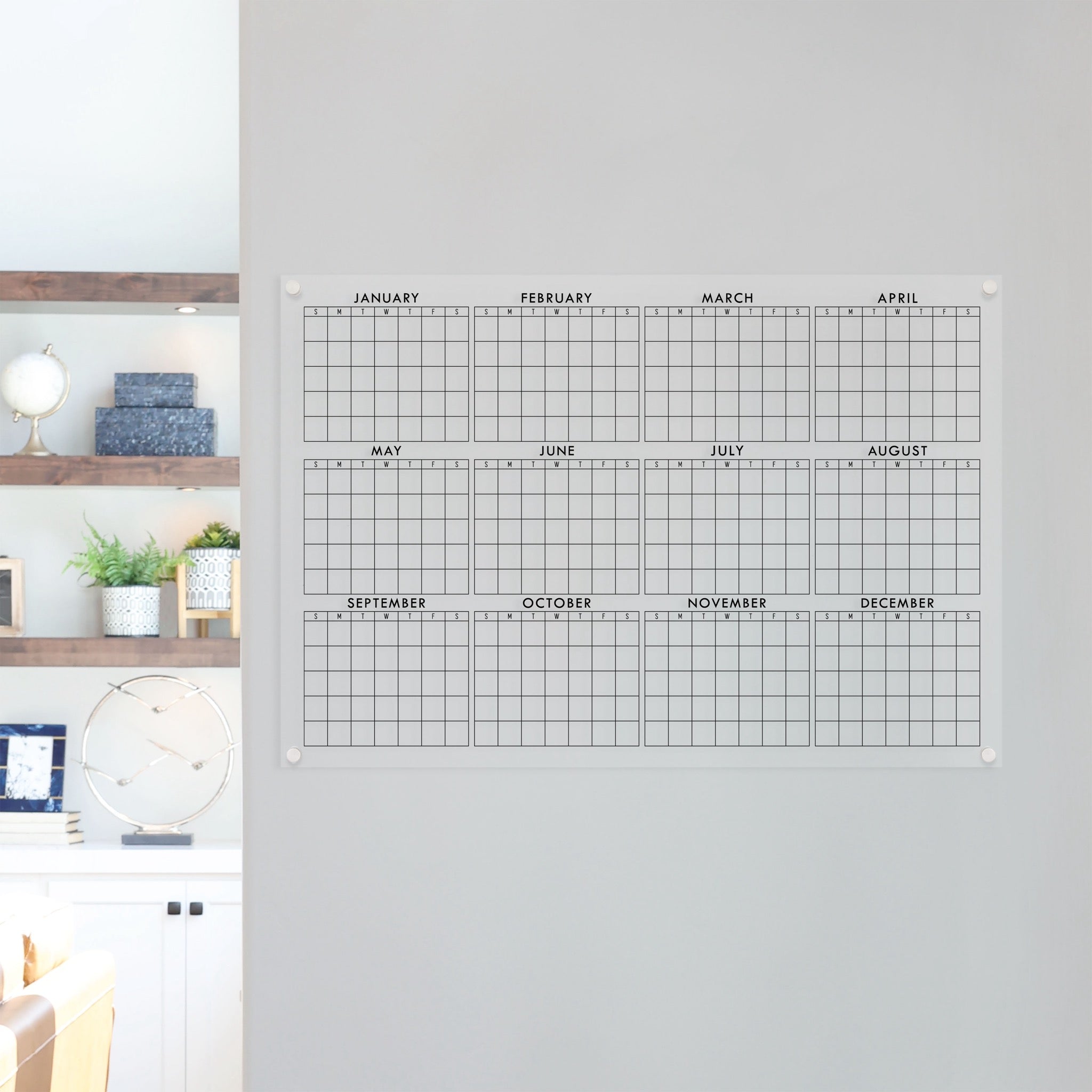 A dry-erase yearly calendar made of acrylic hanging up on the wall