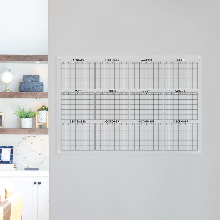 A dry-erase yearly calendar made of acrylic hanging up on the wall