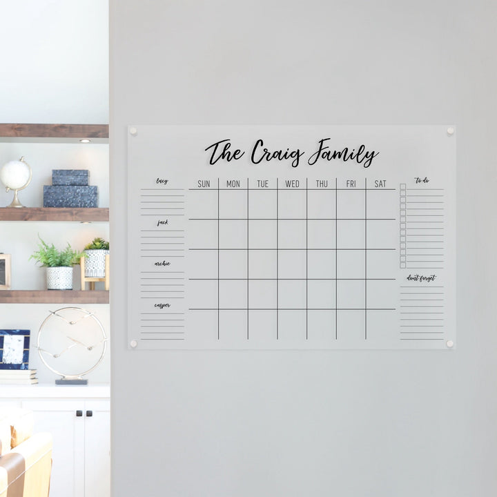 A Dry-erase family command center made of acrylic hanging on the wall