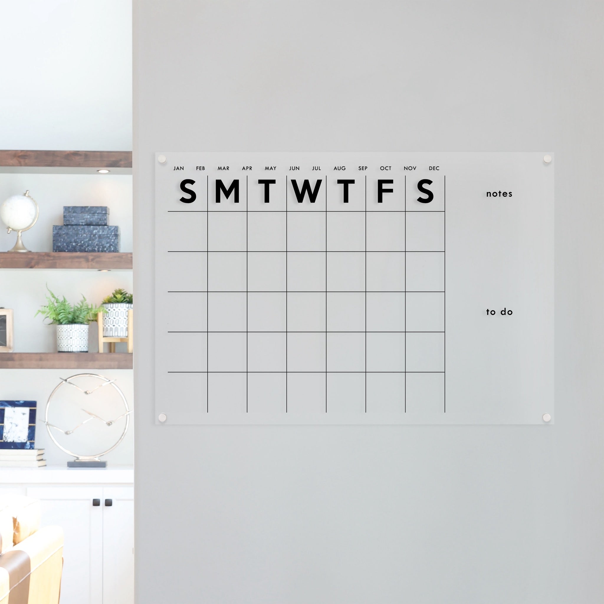 A Dry-erase monthly calender made of acrylic hanging on the wall