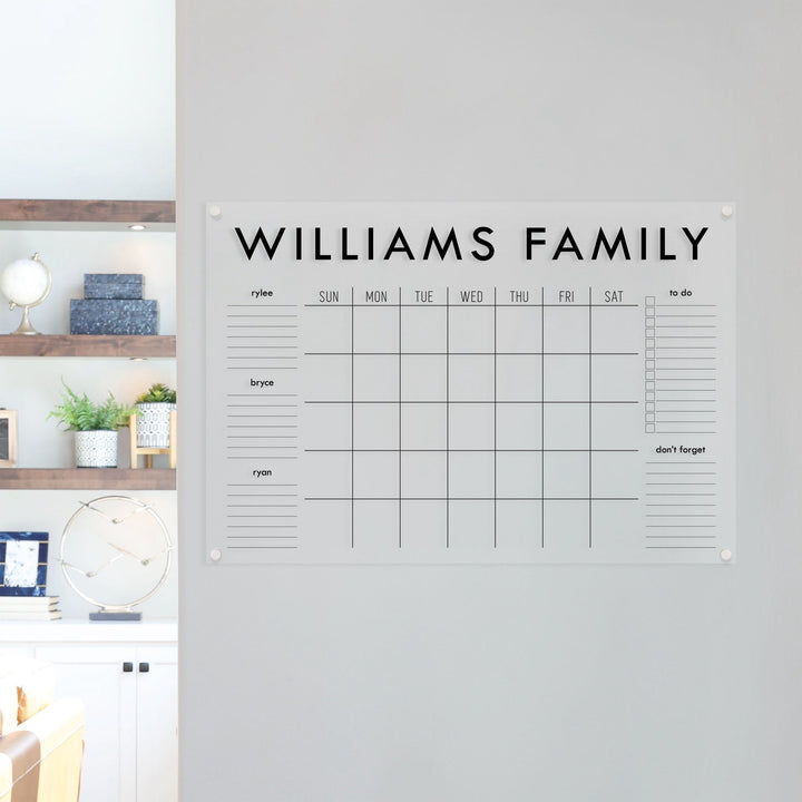 A Dry-erase family command center made of acrylic hanging on the wall