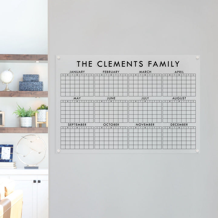 A dry-erase yearly calendar made of acrylic hanging up on the wall