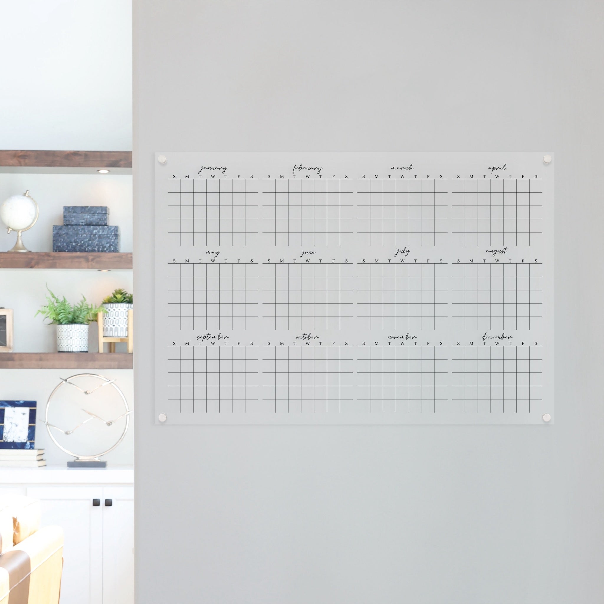 A dry-erase yearly calendar made of acrylic hanging up on the wall