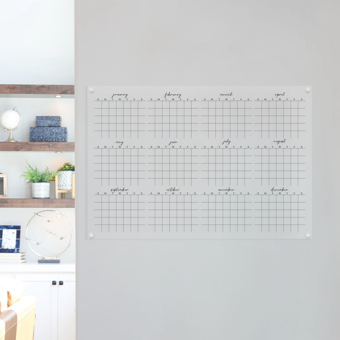 A dry-erase yearly calendar made of acrylic hanging up on the wall