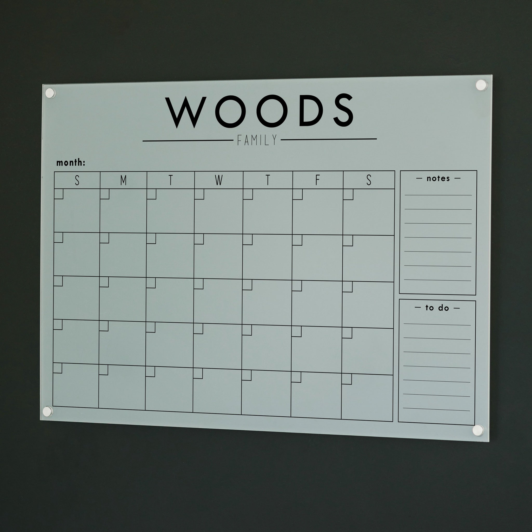 A Dry-erase monthly calender made of acrylic hanging on the wall