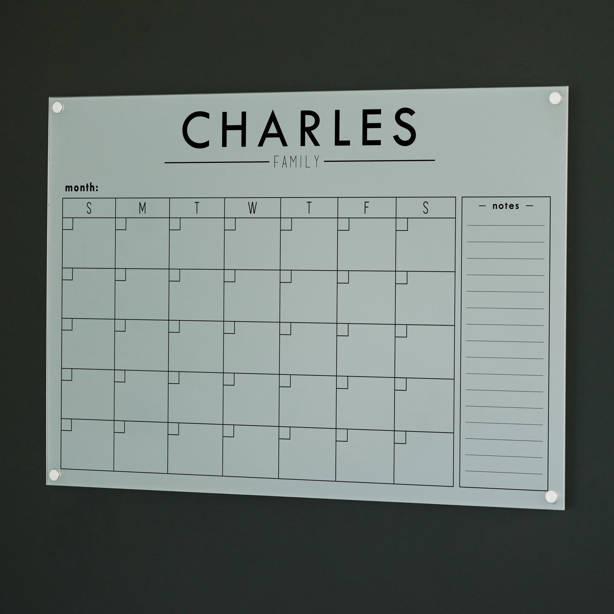 A Dry-erase monthly calender made of acrylic hanging on the wall