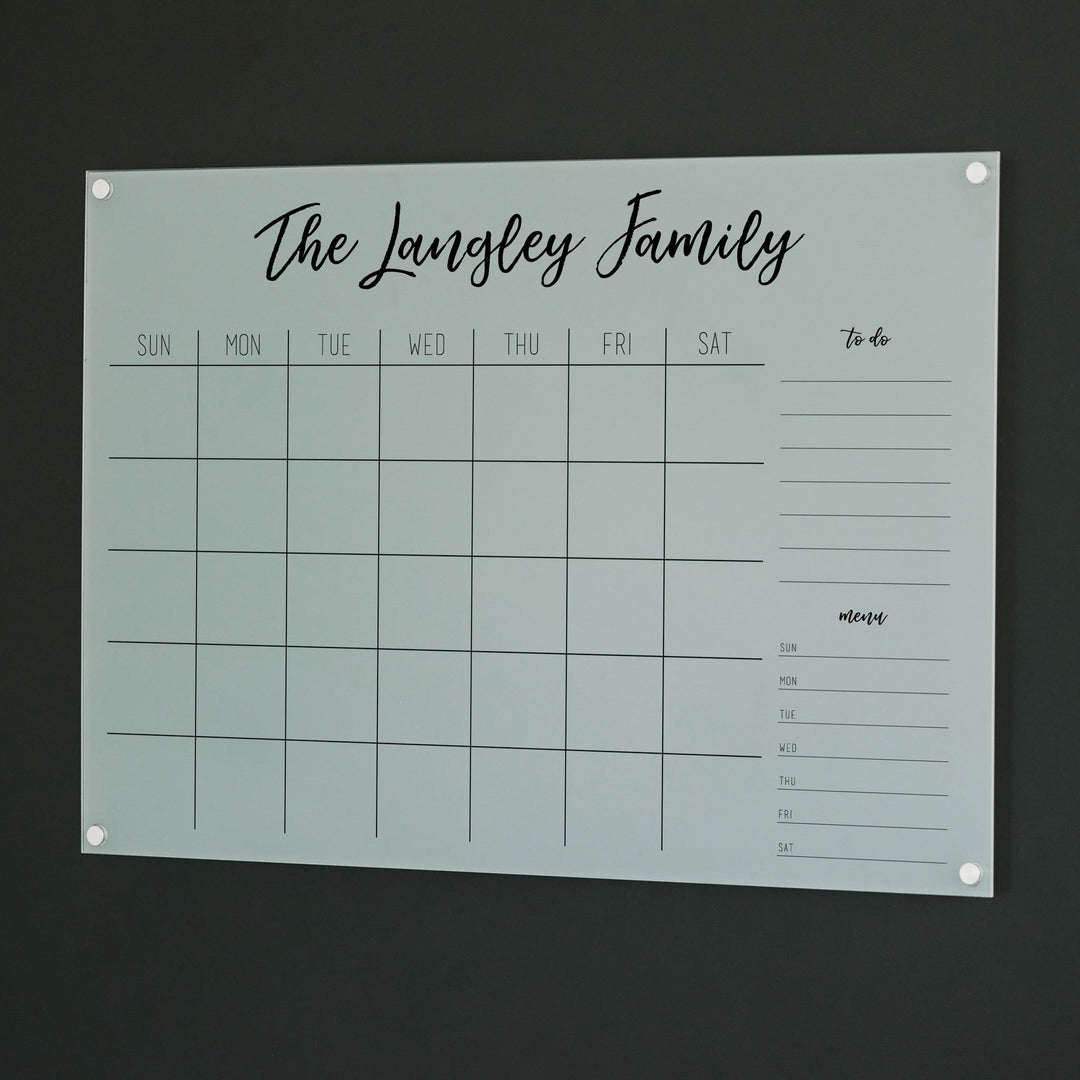A Dry-erase monthly calender made of acrylic hanging on the wall