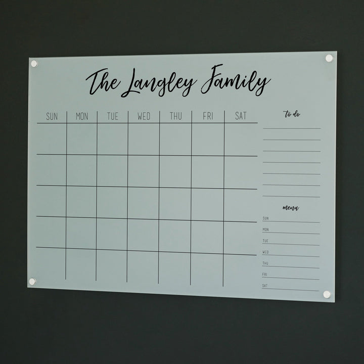 A Dry-erase monthly calender made of acrylic hanging on the wall