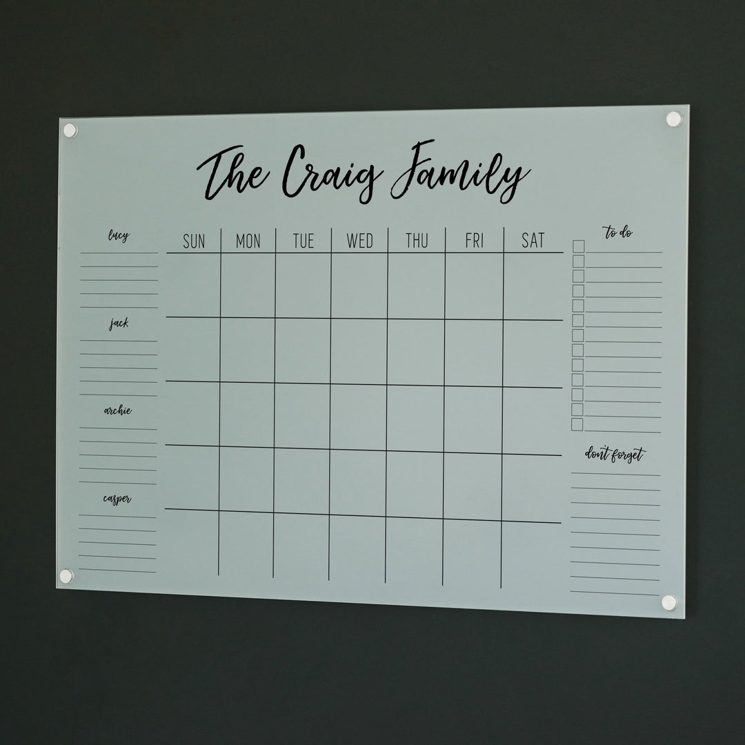 A Dry-erase family command center made of acrylic hanging on the wall