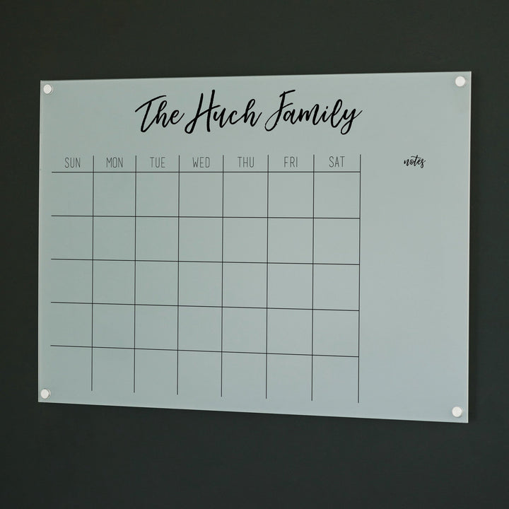 A Dry-erase monthly calender made of acrylic hanging on the wall