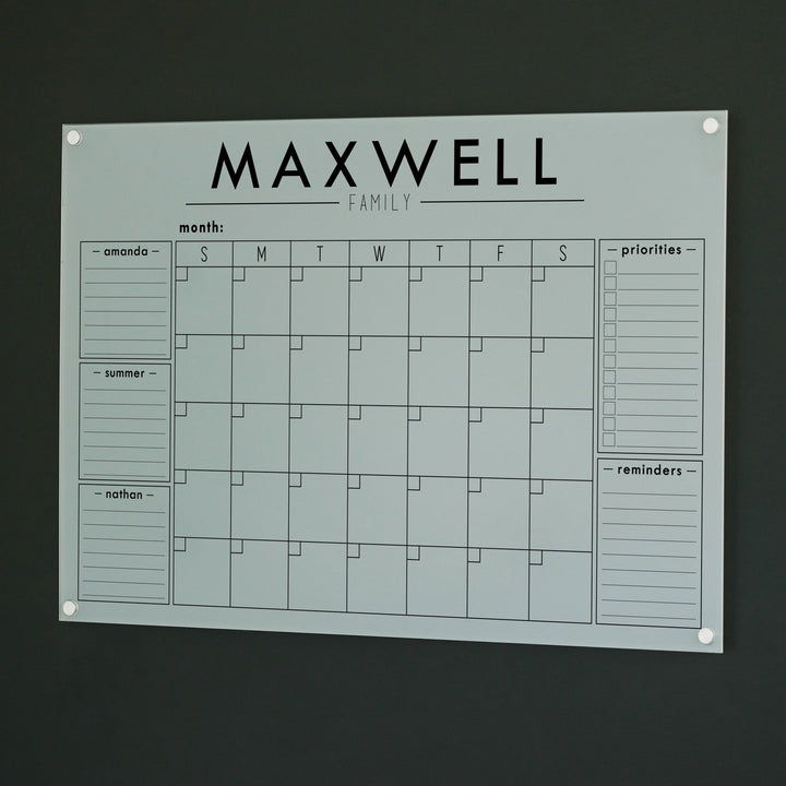A Dry-erase family command center made of acrylic hanging on the wall