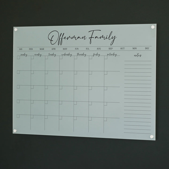 A Dry-erase monthly calender made of acrylic hanging on the wall