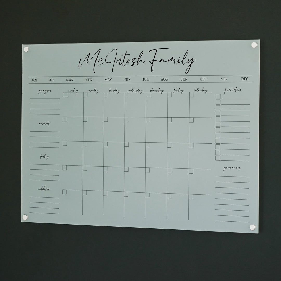 A Dry-erase family command center made of acrylic hanging on the wall