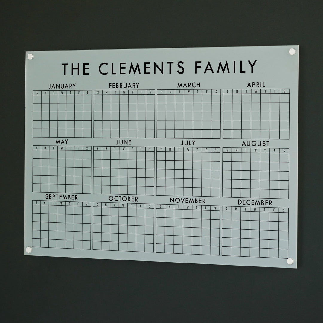 A dry-erase yearly calendar made of acrylic hanging up on the wall