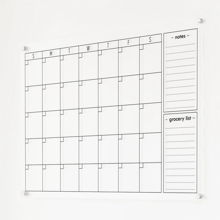 A Dry-erase monthly calender made of acrylic hanging on the wall