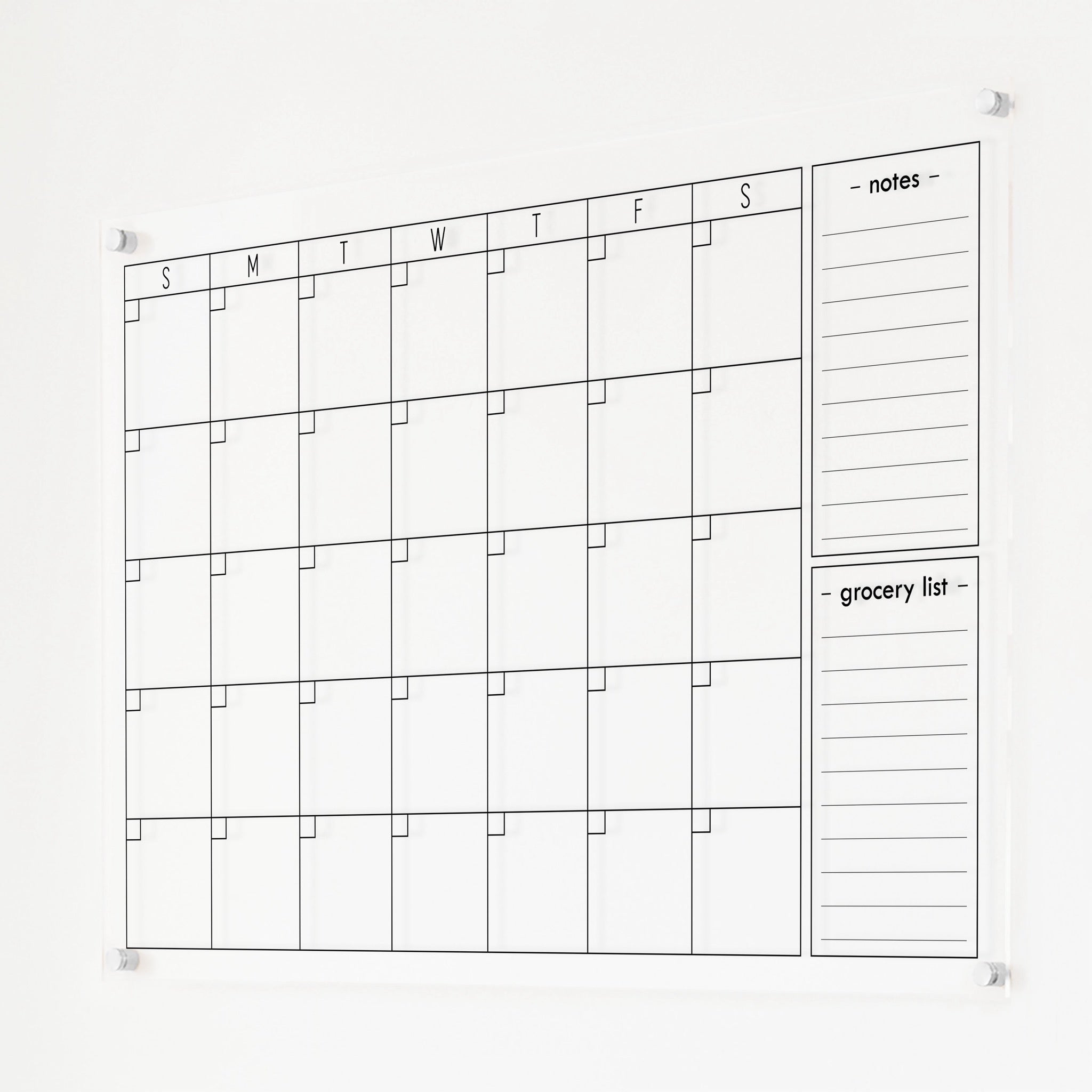 A Dry-erase monthly calender made of acrylic hanging on the wall