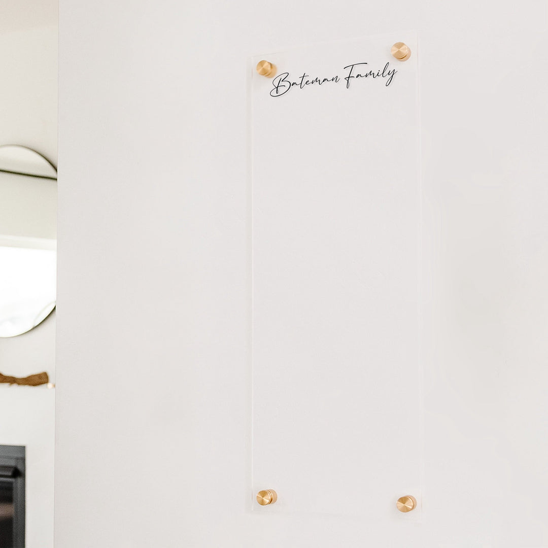 A dry-erase board made of clear acrylic with a custom title up top