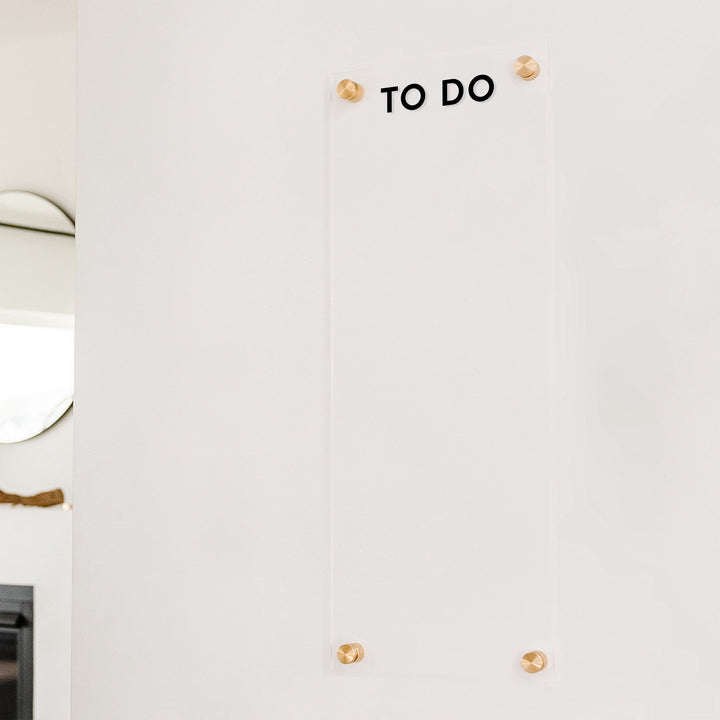 A dry-erase board made of clear acrylic with a custom title up top