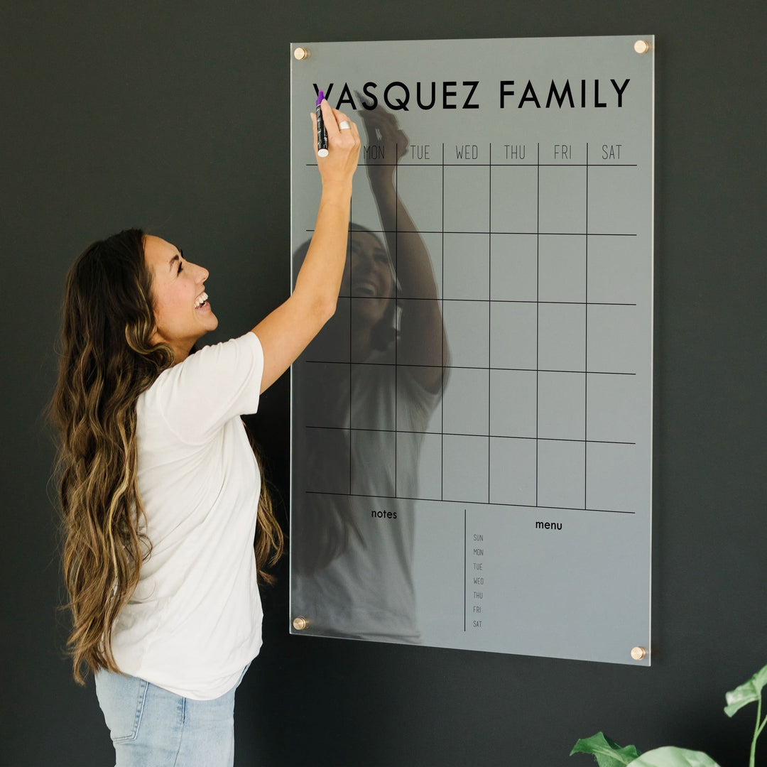 A Dry-erase monthly calender made of acrylic hanging on the wall