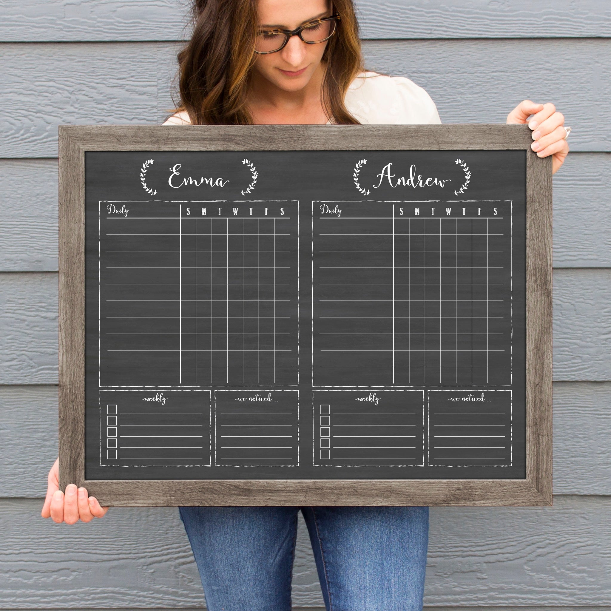 A framed dry-erase chore chart with a chalkboard look hanging on the wall