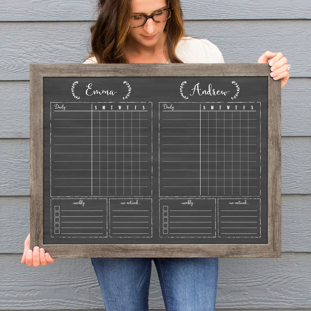 A framed dry-erase chore chart with a chalkboard look hanging on the wall