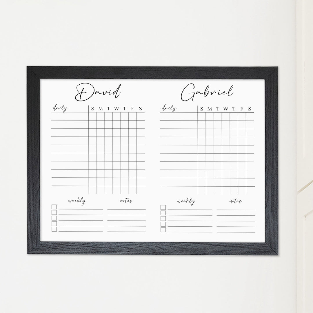 A framed whiteboard chore chart hanging on the wall
