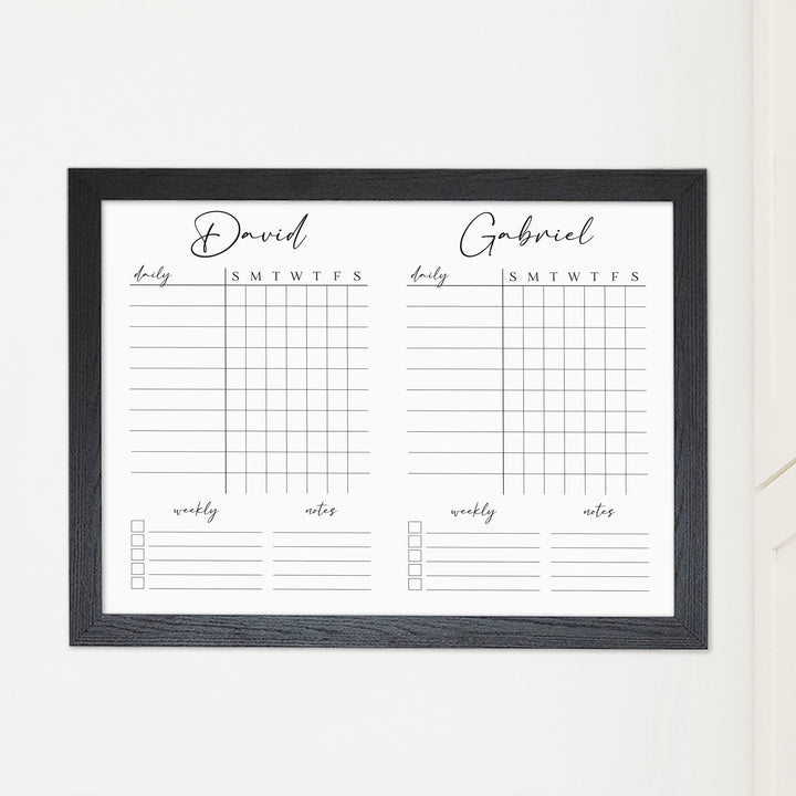 A framed whiteboard chore chart hanging on the wall