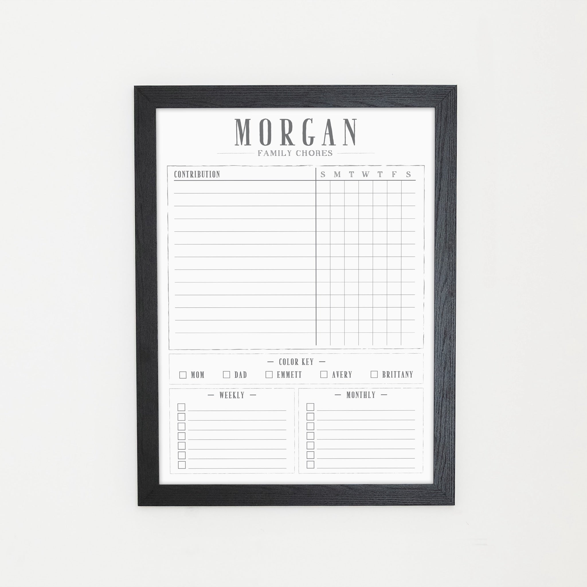 A framed whiteboard chore chart hanging on the wall
