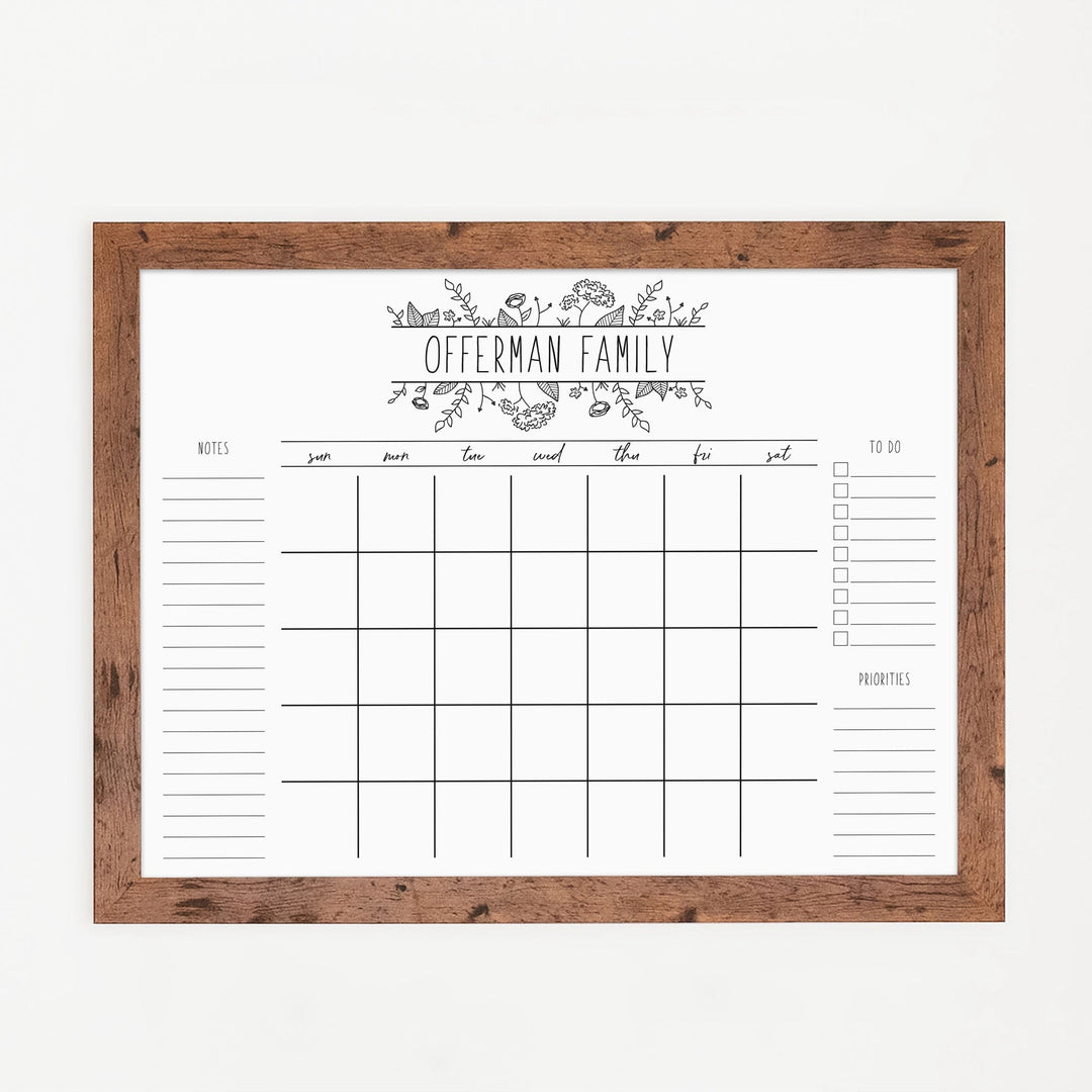 A framed whiteboard monthly calender hanging on the wall